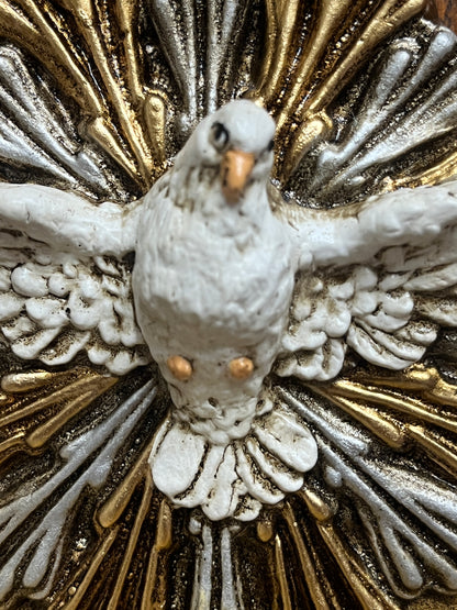 Close-up of hand-painted white dove with gold and silver rays, part of a Holy Spirit holy water font decoration