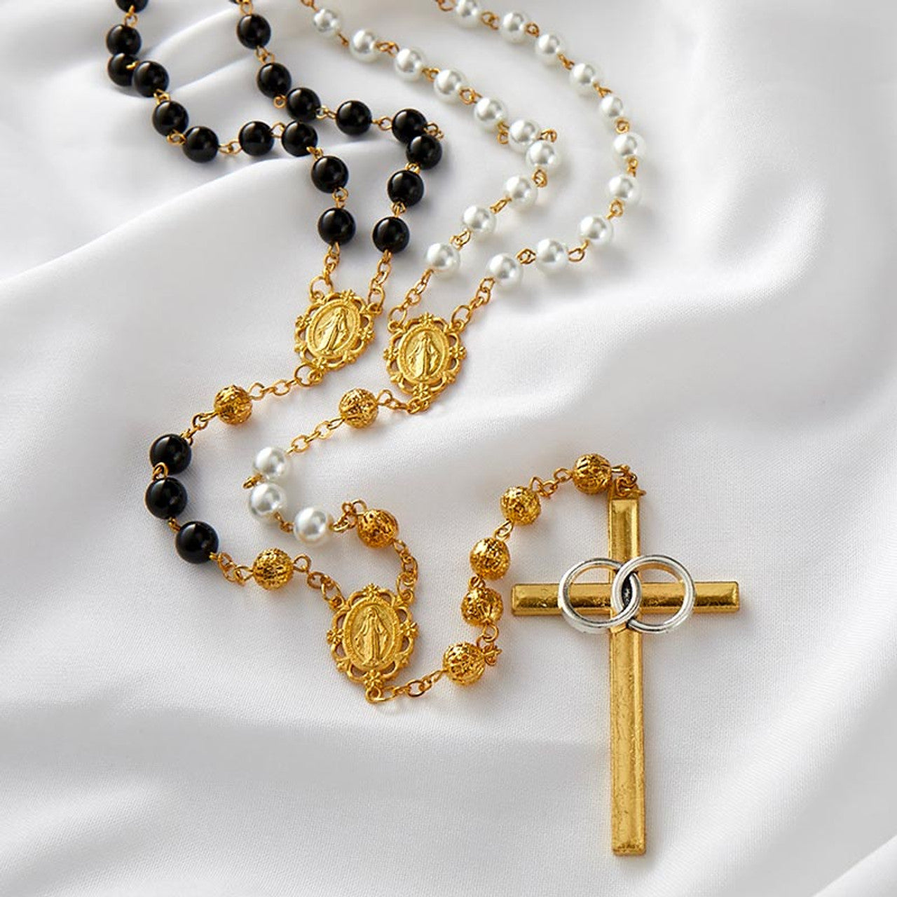 10mm gold faux pearl lasso rosary with detailed medallions, black and white beads, and gold cross with interlocking rings