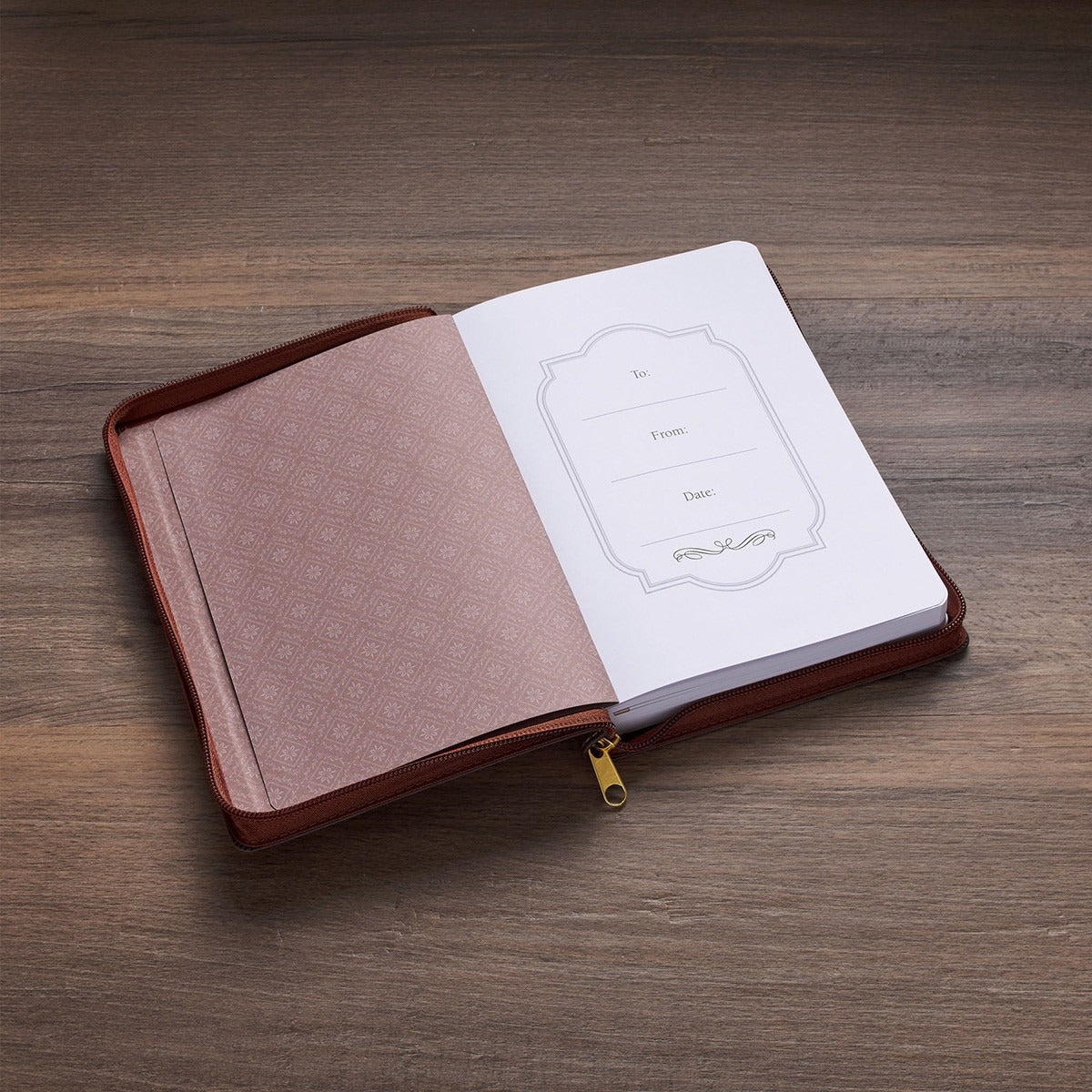 8" two-tone brown faux leather journal with zipper closure, open to gift label page on wooden surface