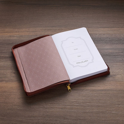 8" two-tone brown faux leather journal with zipper closure, open to gift label page on wooden surface