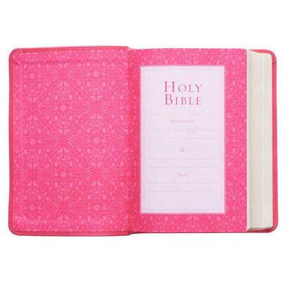 Pink faux leather large print compact King James Version Bible open to decorative presentation page with floral pattern interior