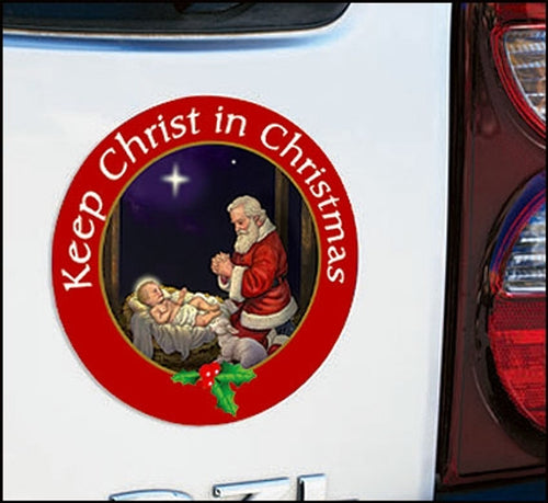 3" Keep Christ in Christmas auto magnet featuring Santa kneeling in prayer before baby Jesus with red border and holly accents