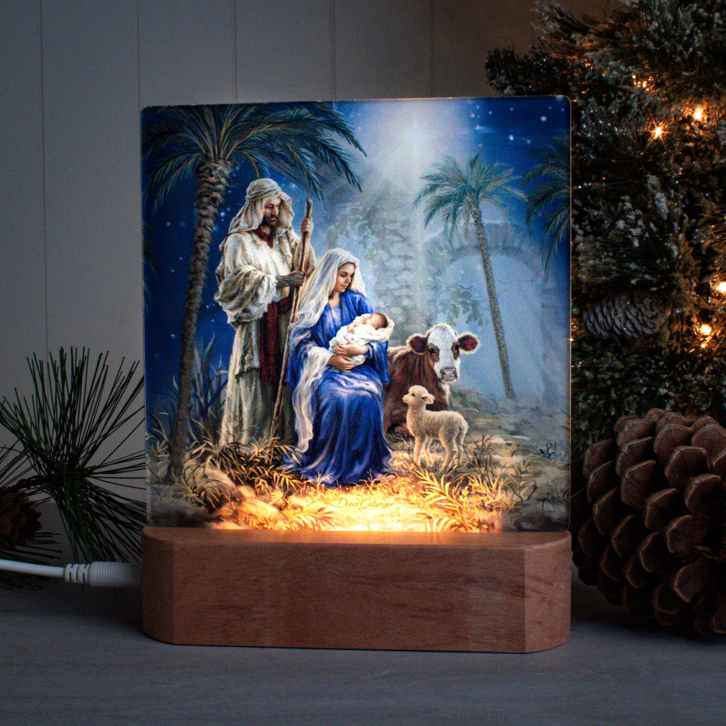 Holy Night tabletop LED nightlight showing Mary holding baby Jesus, with Joseph, a cow, and lamb in stable scene