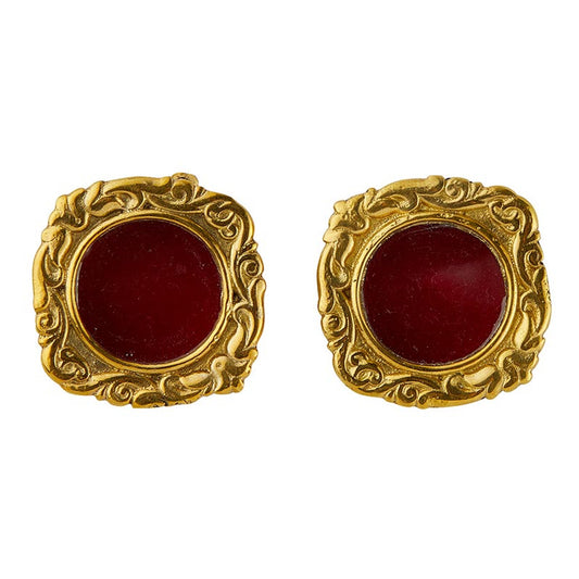 Pair of small round mini reliquaries with ornate gold-toned frames and deep red centers on white background