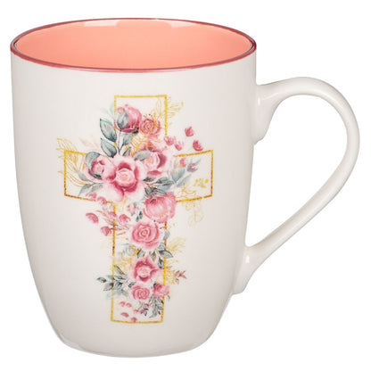 Ceramic coffee mug with pink floral cross design and soft coral interior on white background