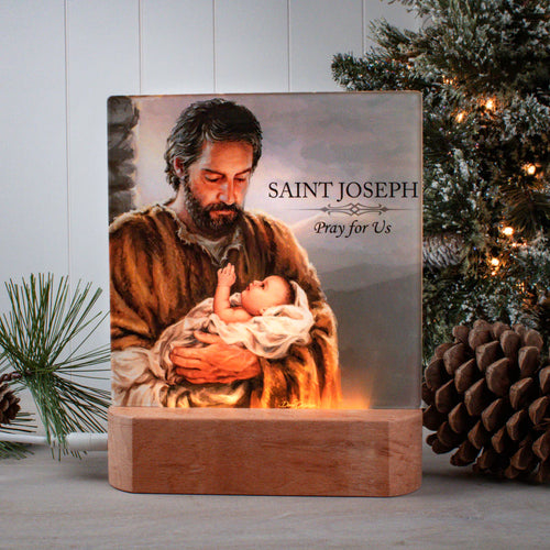 7" Saint Joseph LED nightlight showing tender embrace of Joseph holding baby Jesus with warm glowing base and prayer text
