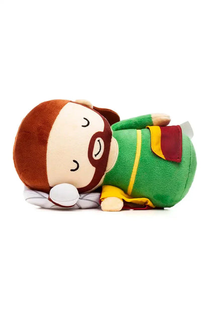 Sleeping plush doll of Saint Joseph in green and yellow robe with brown beard lying on white pillow