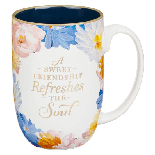 Ceramic mug with watercolor floral design and gold text reading “A sweet friendship refreshes the soul” on white background