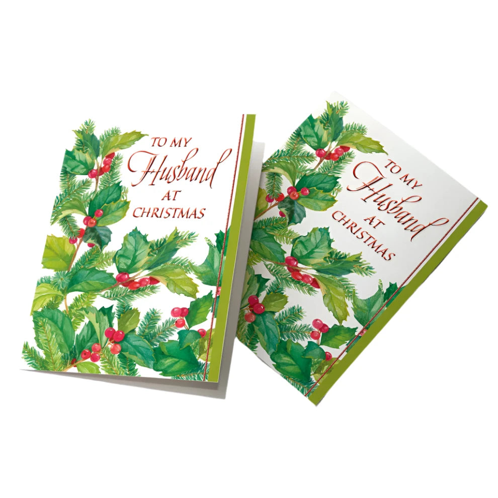 Christmas card for husband with holly and evergreen design and red script text "To My Husband at Christmas" on white background