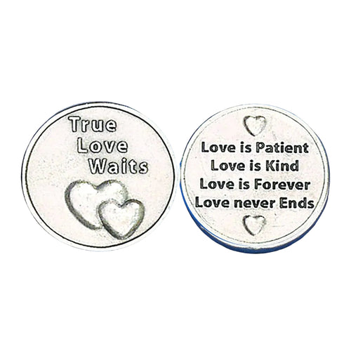 Two round silver-toned metal coins or medallions shown side by side on a textured blue background. The left coin reads 'True Love Waits' with two heart designs, and the right coin reads 'Love is Patient Love is Kind Love is Forever Love never Ends' with small heart motifs.