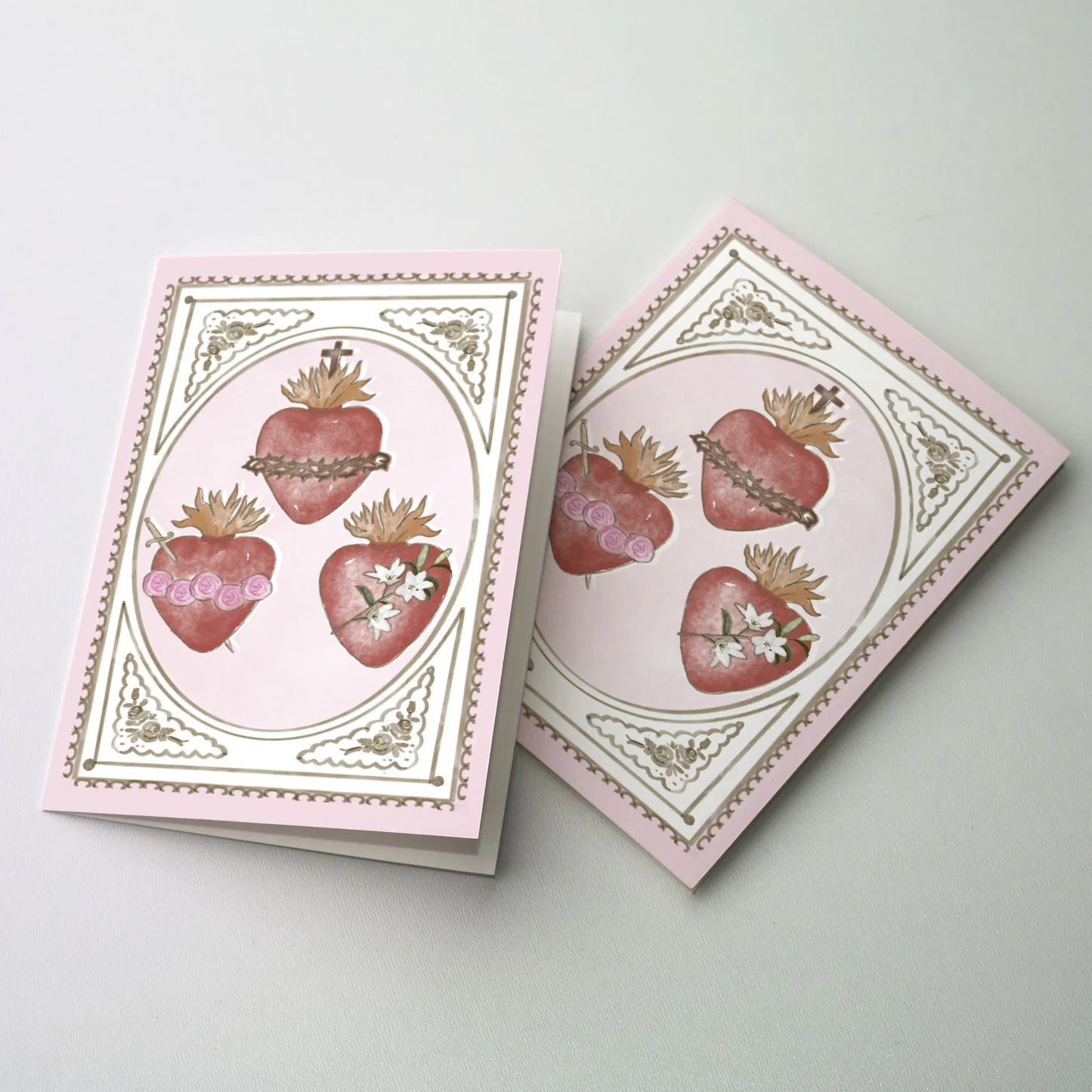 Valentine greeting card with Sacred Heart, Immaculate Heart, and Chaste Heart illustrations framed in gold on pink background