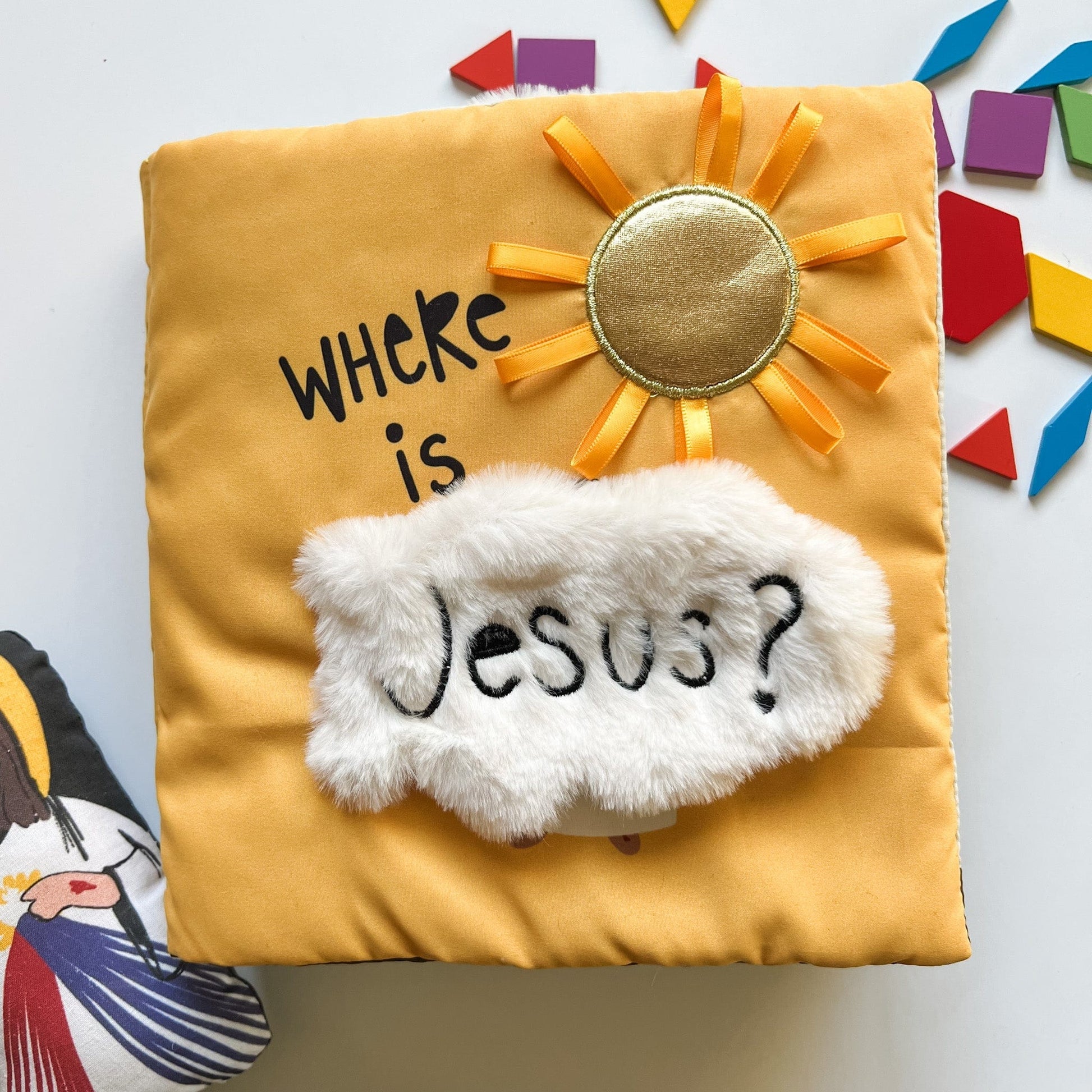 Soft yellow fabric cover of "Where is Jesus?" Mass quiet book with sun and fluffy white cloud detail