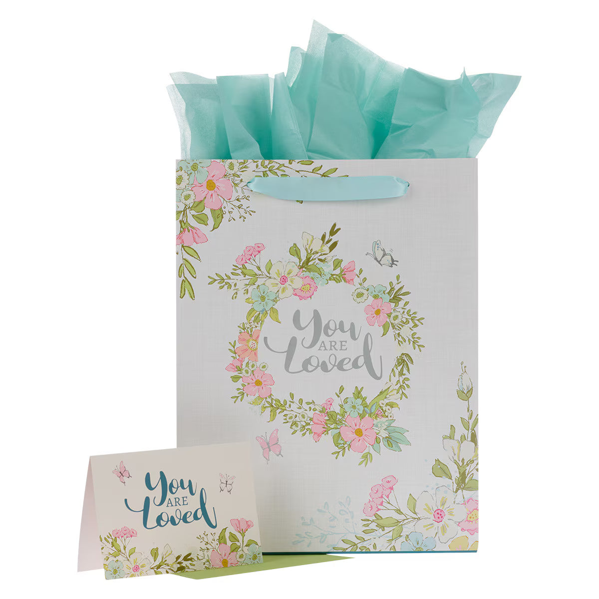 Large portrait gift bag with pink floral wreath and "You are Loved" text, matching card and light blue tissue paper