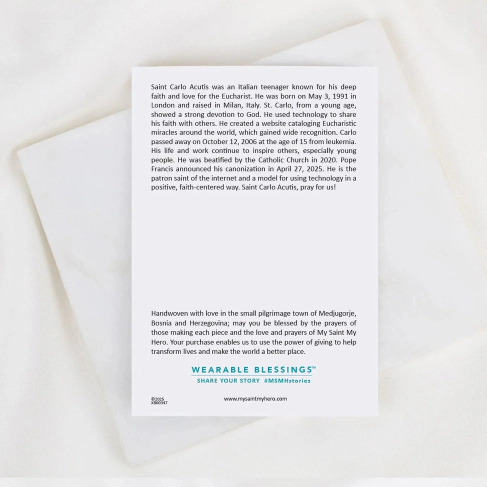 Back of Saint Carlo Acutis bracelet card with biography text and Wearable Blessings logo on white background
