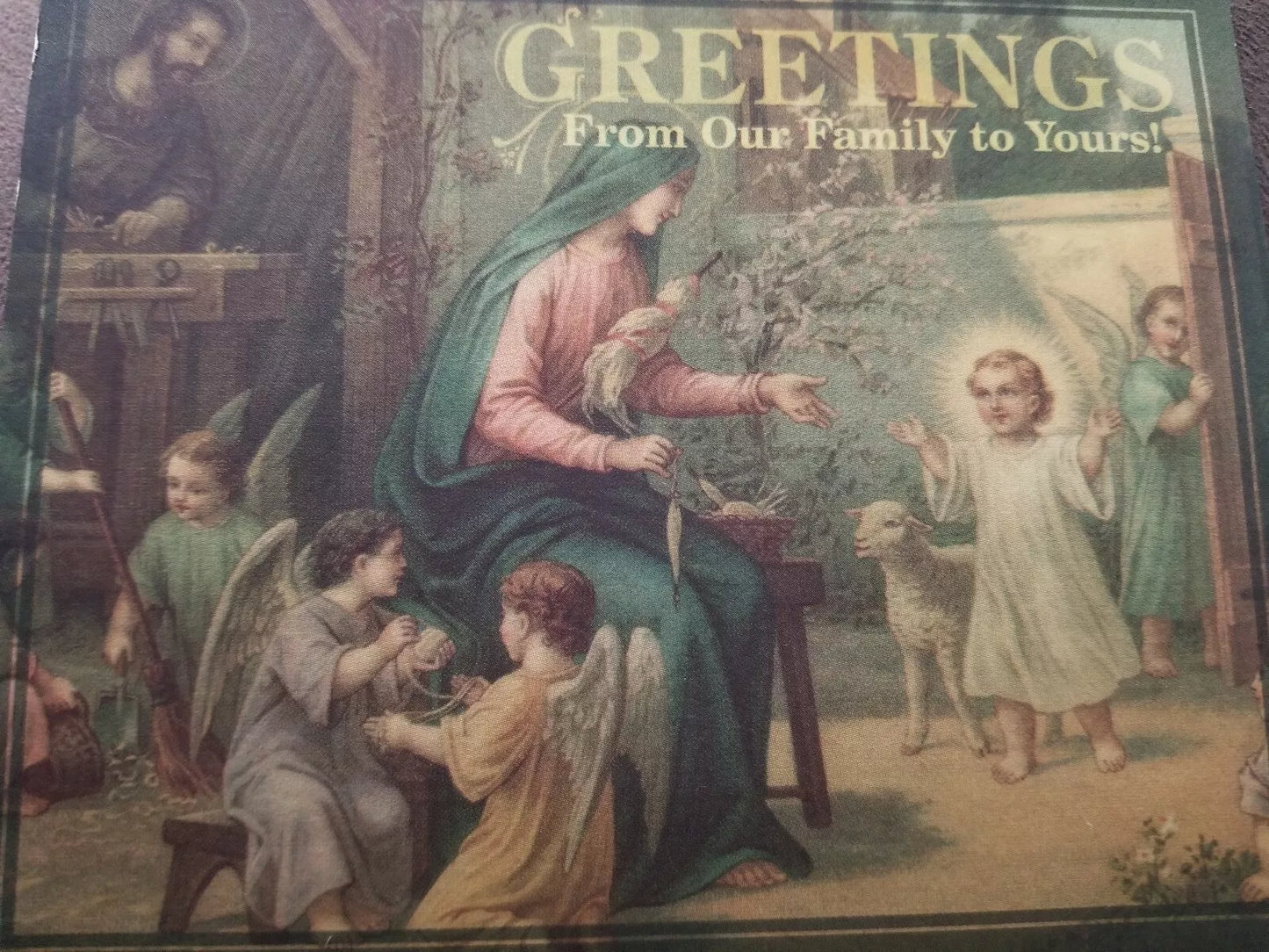 Religious greeting card featuring Mary, angels, and child with lamb, titled Greetings From Our Family to Yours.