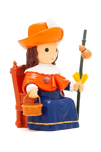 3.5" Niño de Atocha Collector's Edition figurine seated with orange hat, basket, staff, and blue and orange pilgrim attire
