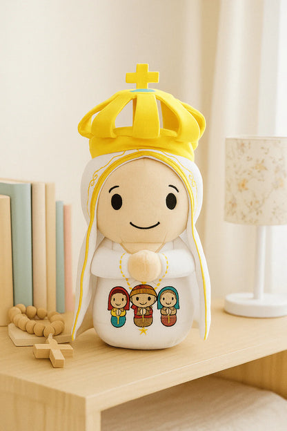 Our Lady of Fatima 9" plush doll with yellow crown, embroidered three children, and praying hands on wooden shelf