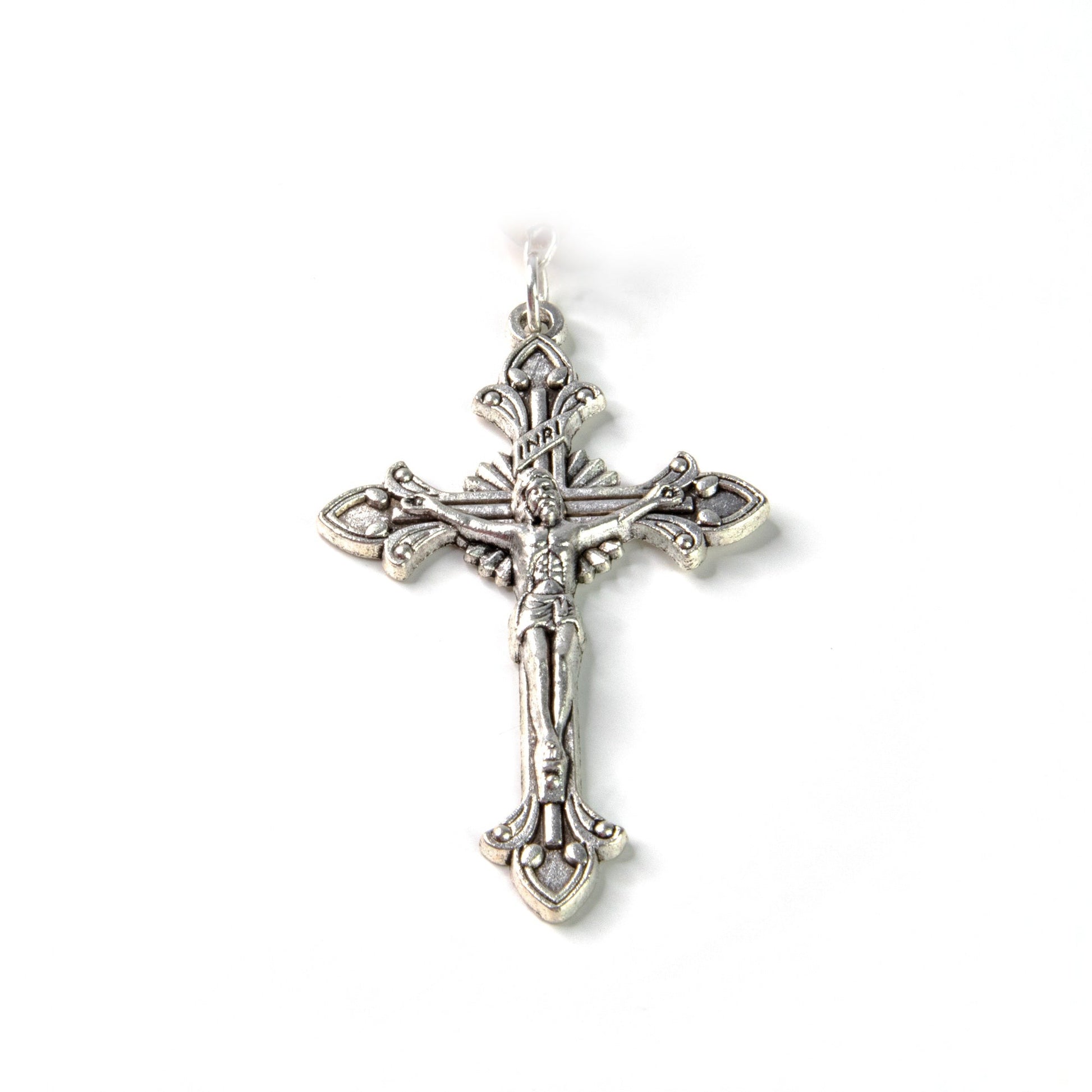 Detailed silver crucifix pendant with ornate fleur-de-lis design and INRI inscription on white background