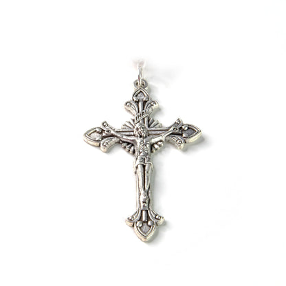 Detailed silver crucifix pendant with ornate fleur-de-lis design and INRI inscription on white background